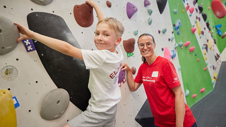 Little boy with woman on climbing wall.