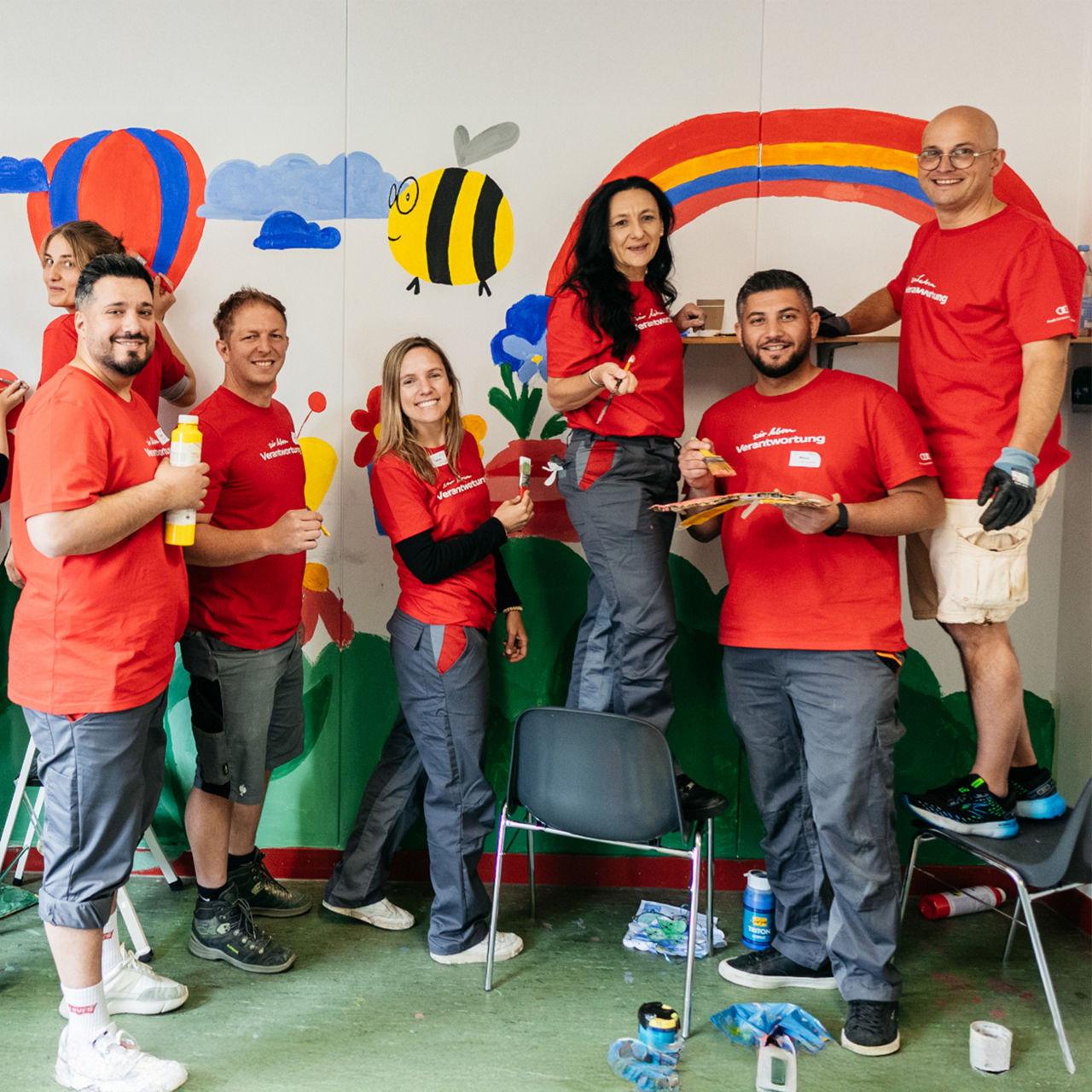 The Chairman of the General Works Council at Audi, Jörg Schlagbauer, stands in a room with colleagues and paints the walls with bright colors.