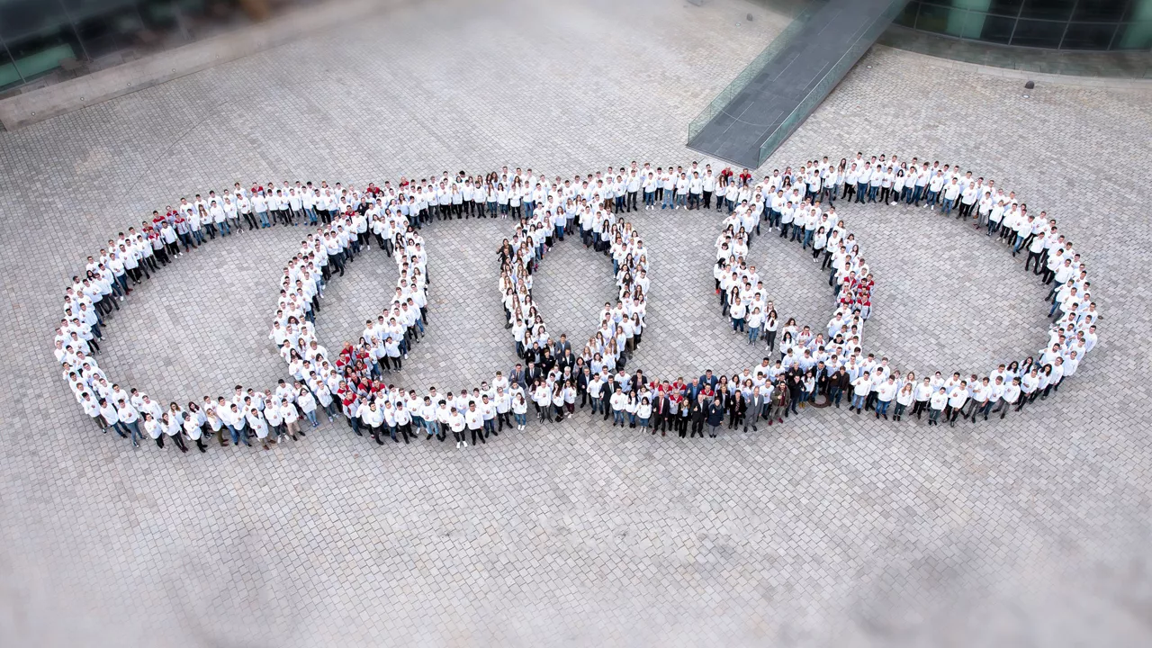 Many employees stand in the shape of the four rings and are photographed from above