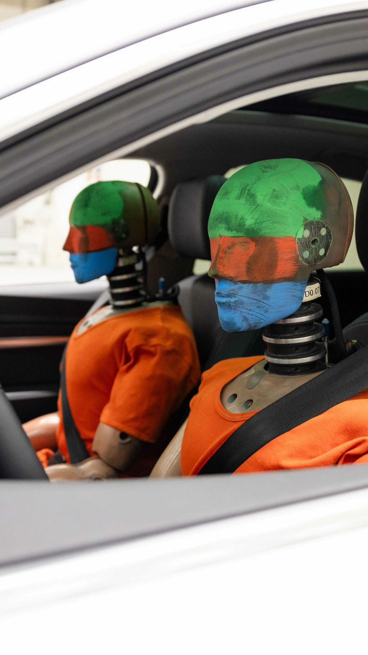 Two dummies sit in the driver and passenger seats of an Audi for a crash test