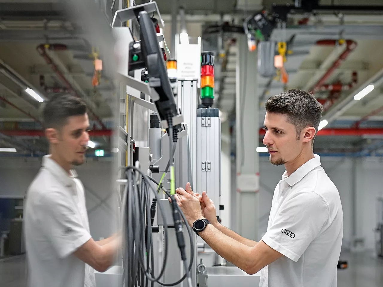 Junger Mitarbeiter steht an einer Produktionsmaschine