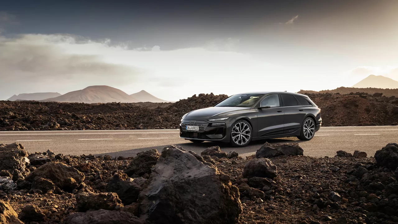 Der Audi A6 Avant e-tron performance steht auf einer Straße vor einer Bergkulisse. Neben der Straße liegen Steine und Geröll.