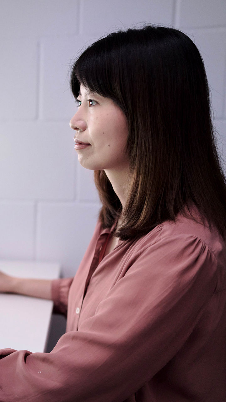 jiayi sitzt am Computer und schaut auf den Bildschirm