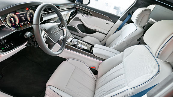 Audi interior with light leather seats, digital cockpit, and center console.