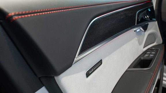 Door panel with red stitching and Audi exclusive badge.