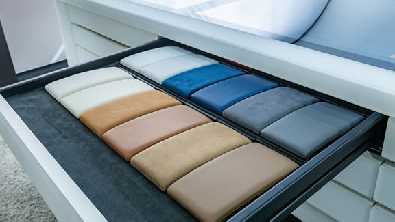 Leather samples in various colors and materials in an open drawer.