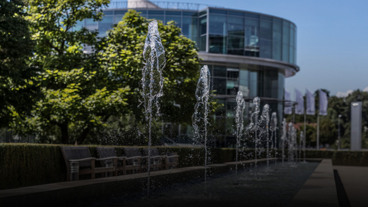 Gebäude des Audi Forum Ingolstadt, davor kleine Wasserfontänen.