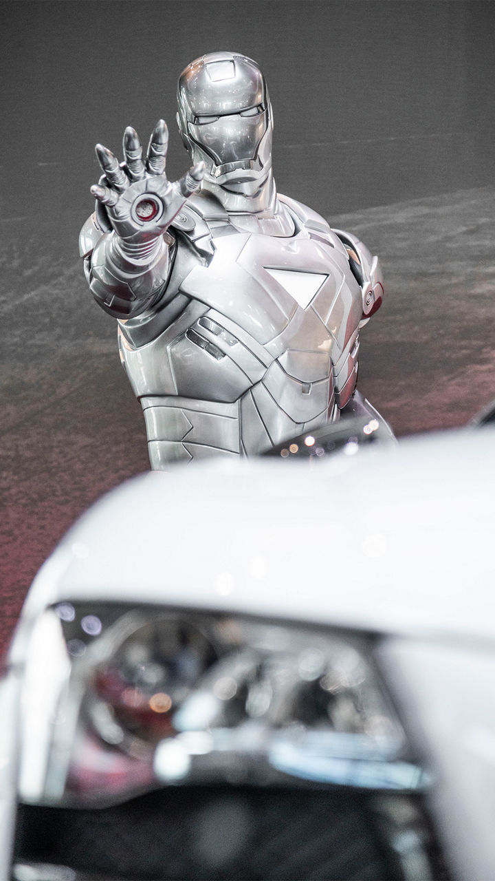 Ein silberner Iron-Man-Darsteller posiert vor einem weißen Audi R8, daneben ein Audi R8 LMS auf der Rennstrecke und unten ein weißer Audi R8 in Fahrt in einem Tunnel.