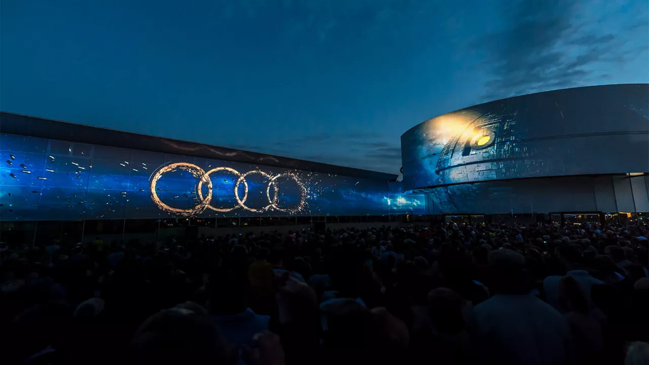 Projection of the four Audi rings against the dark evening sky