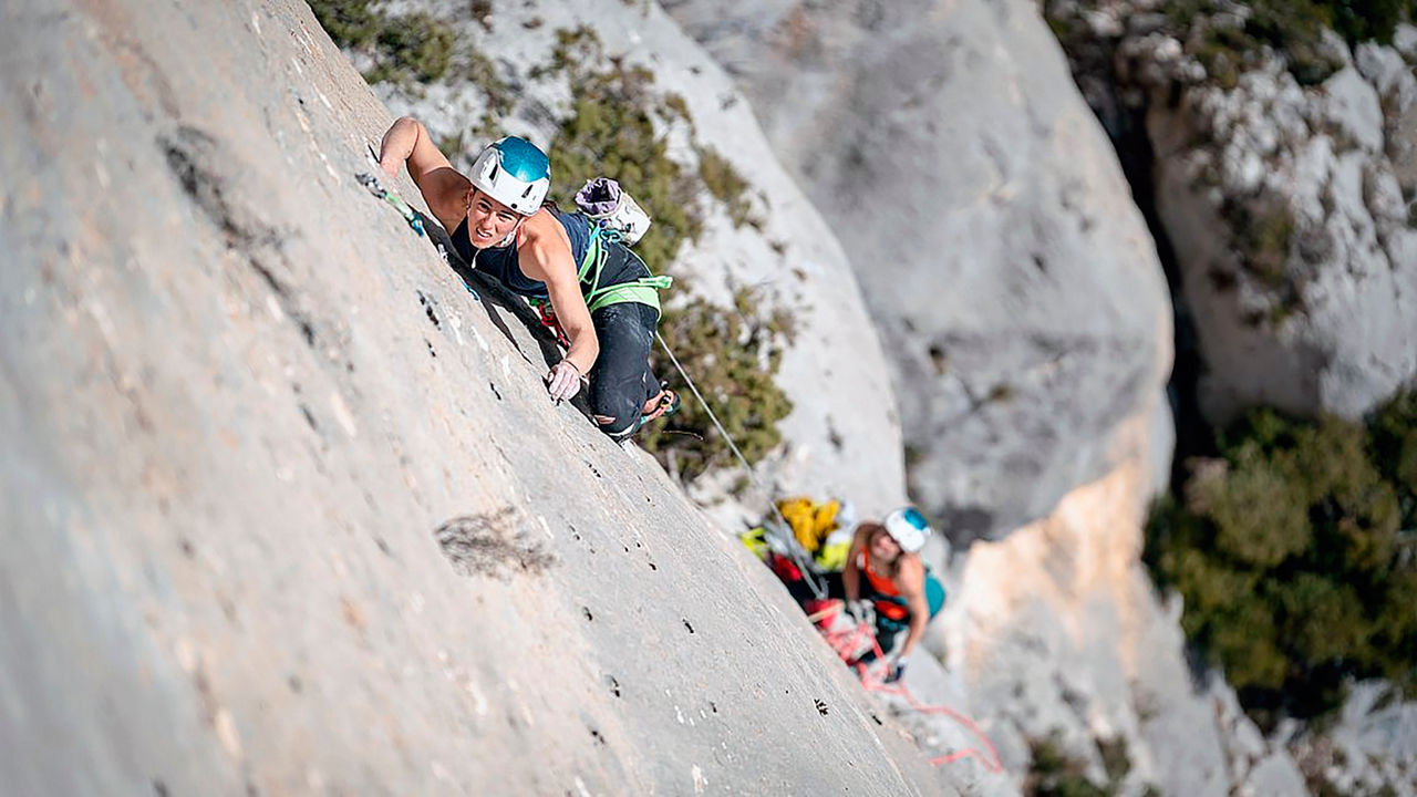 Zwei Personen in Ausrüstung klettern Berge hoch