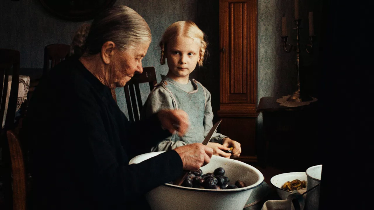 Ein junges Mädchen bereitet mit ihrer Oma das Essen vor.