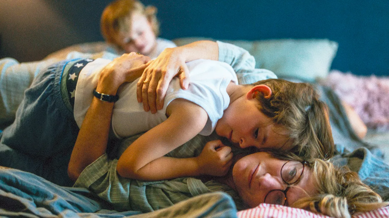 Sandra kuschelt auf dem Bett mit der kleinen Tochter des Nachbarn.