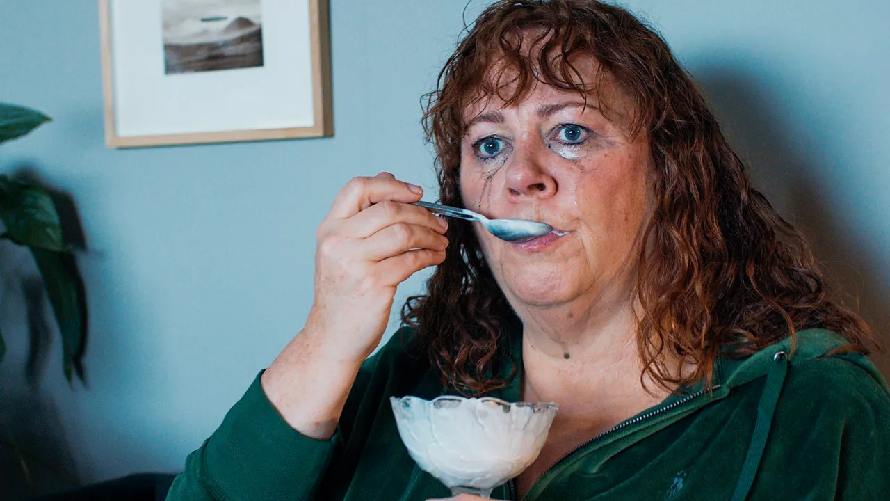 Eine kräftig gebaute Musikerin verdrängt ihre Sorgen mit einem üppigen Sahne-Dessert.