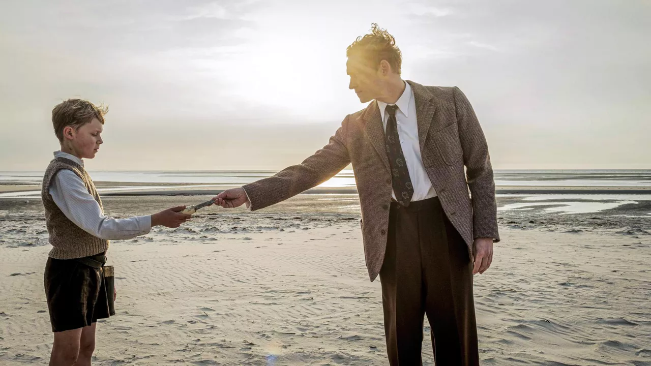 Der 12-jährige Nanning steht zusammen mit einem Erwachsenen am Strand von Amrum.