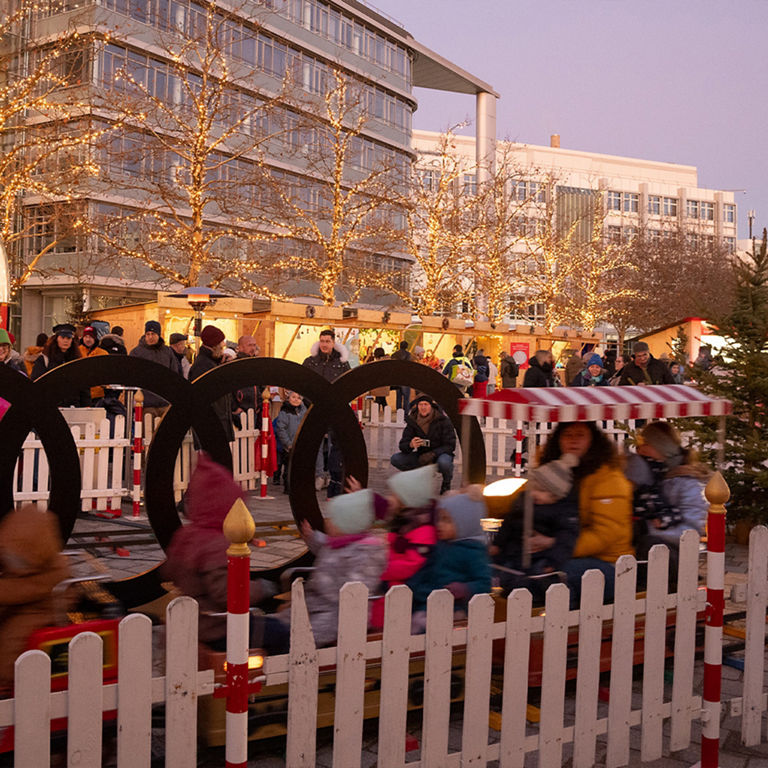 Kids and grown ups on a train on the audi social christmas market.