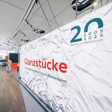 Großes Transparent mit der Aufschrift „Glanzstücke - Sonderausstellung im Audi Forum Neckarsulm“ anlässlich des 20-jährigen Jubiläums.
