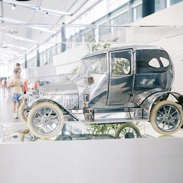 Detailaufnahme eines glänzenden historischen Automodells in einer Vitrine im Audi Forum Neckarsulm.
