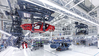 The body of an Audi is guided through the stations using a rail system on the ceiling.