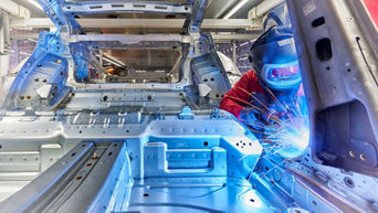 A welder welds a seam on a car body.