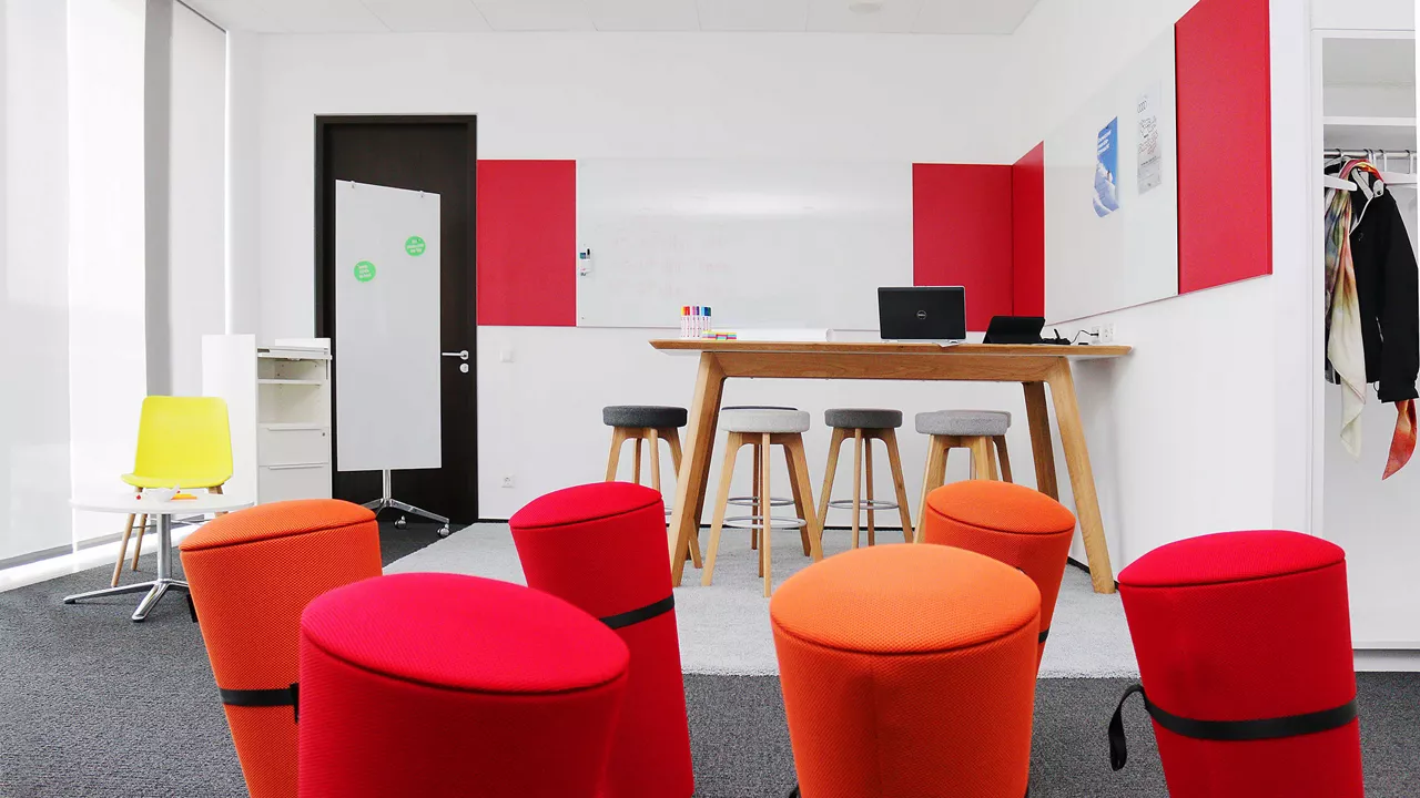 View of a creative room with stools, whiteboard and desk