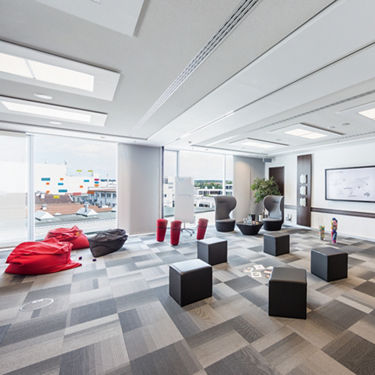 View of a creative room with red beanbags, stools and post it at the window front.