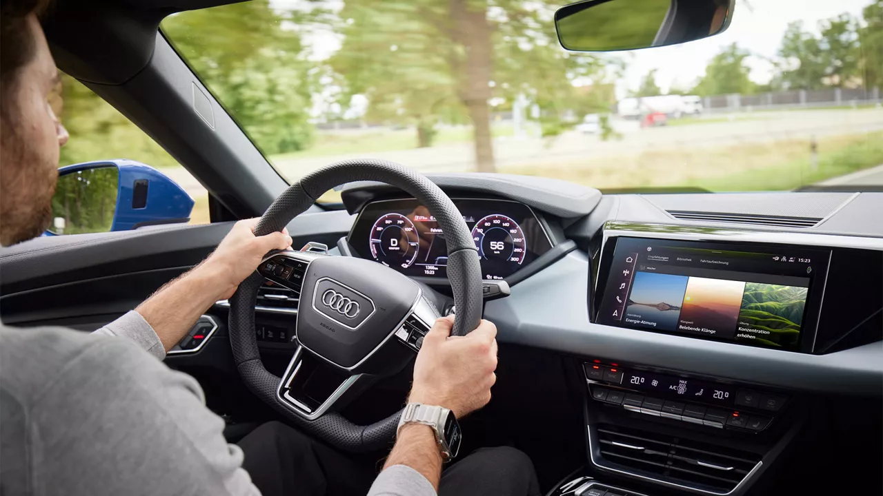 Person sitzt am Lenkrad eines Audi