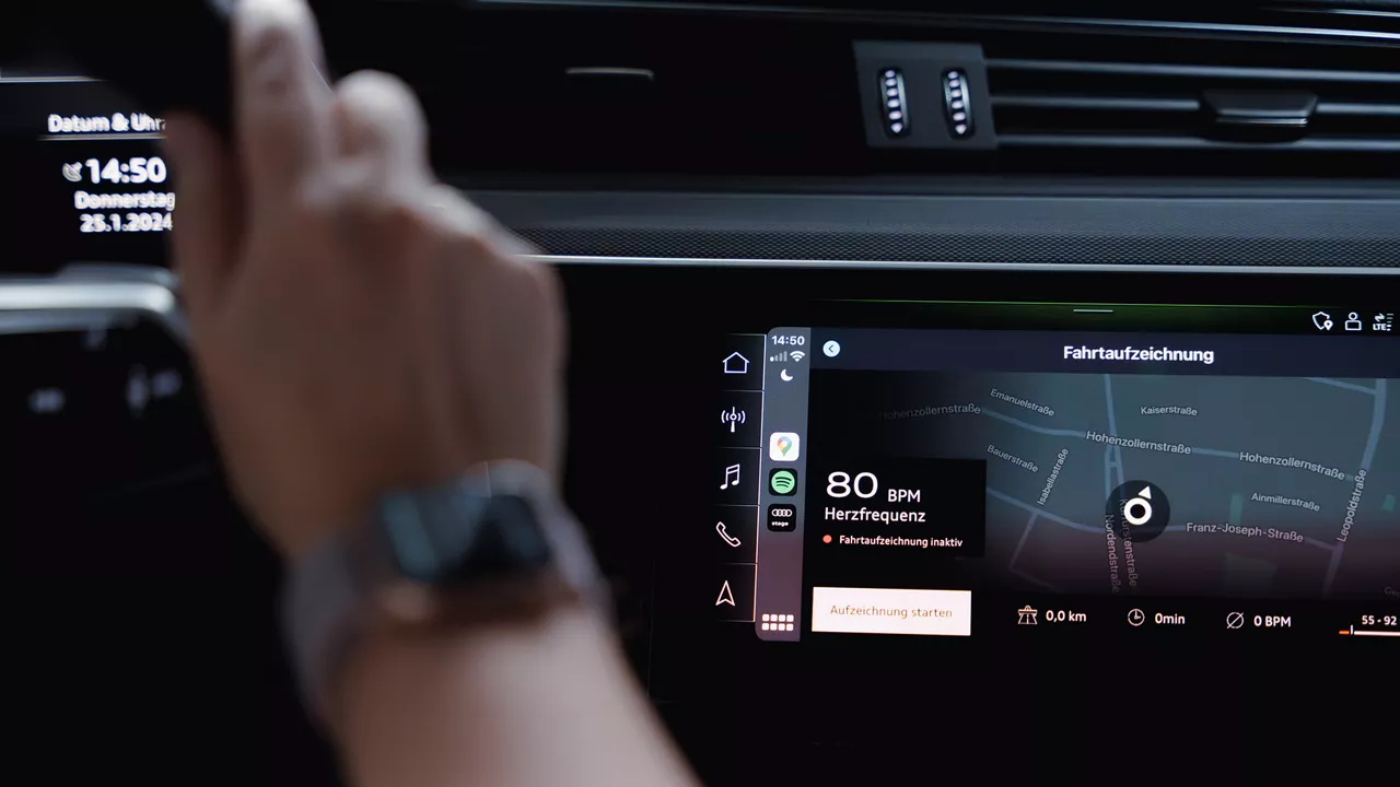 Eine Hand tippt auf dem Display im Audi Modell