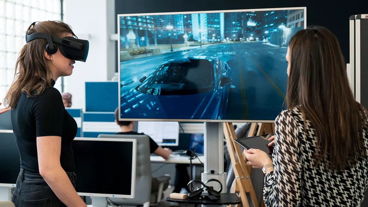 Frauen stehen mit VR-Brille vor einem Bildschirm