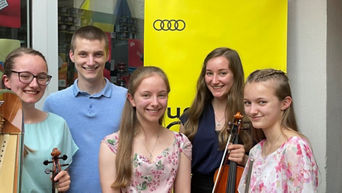Die Drew Family steht vor einem Schild der Audi Sommerkonzerte