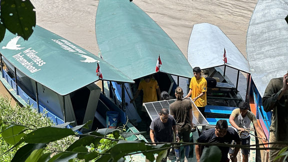 People load boats with solar panels