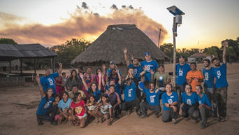Gruppe von Volunteers mit einer Gruppe von Indigenen