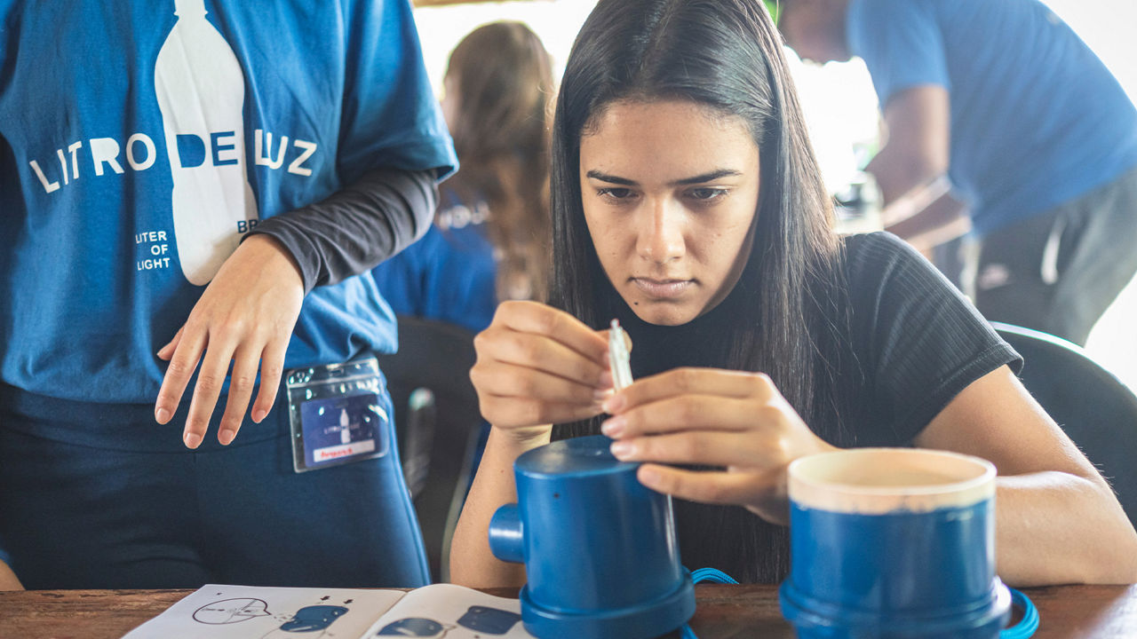 Young woman working on a light source.