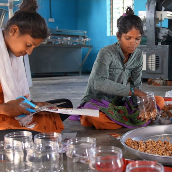 Three women sit in a circle and work.