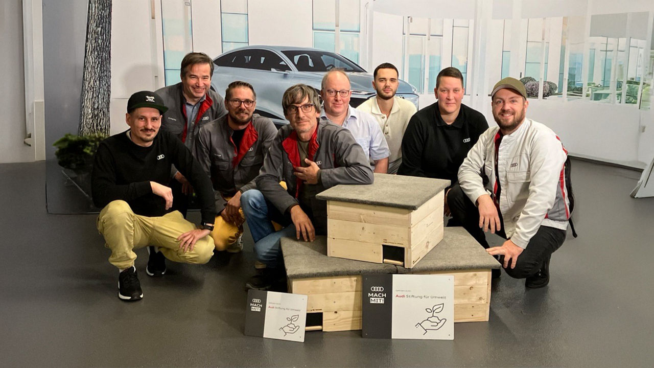 Gruppe posiert mit Igelhäusern
