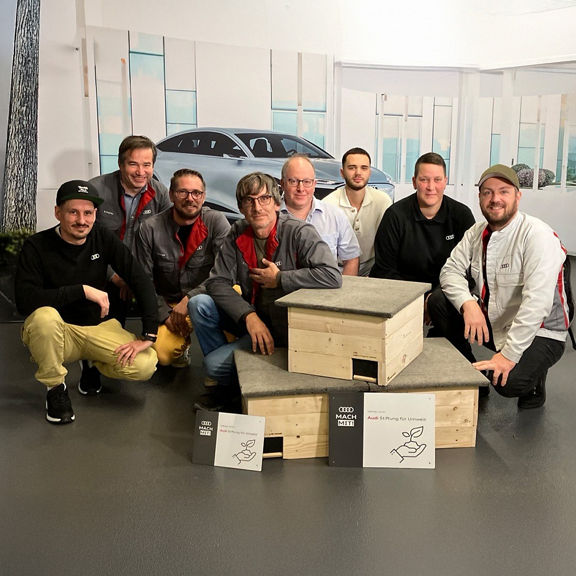 Gruppe posiert mit Igelhäusern