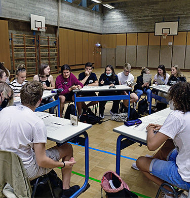 Schüler sitzen im Stuhlkreis und stellen eine Klimakonferenz nach
