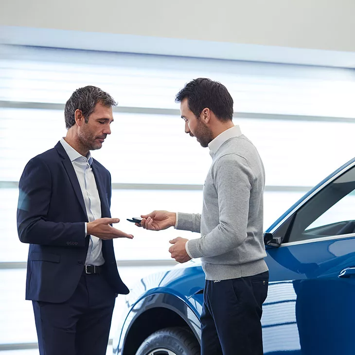 Image of Audi dealer service attendant handing keys to customer