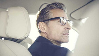 Side profile of man wearing glasses sitting in his Audi peering into the distance