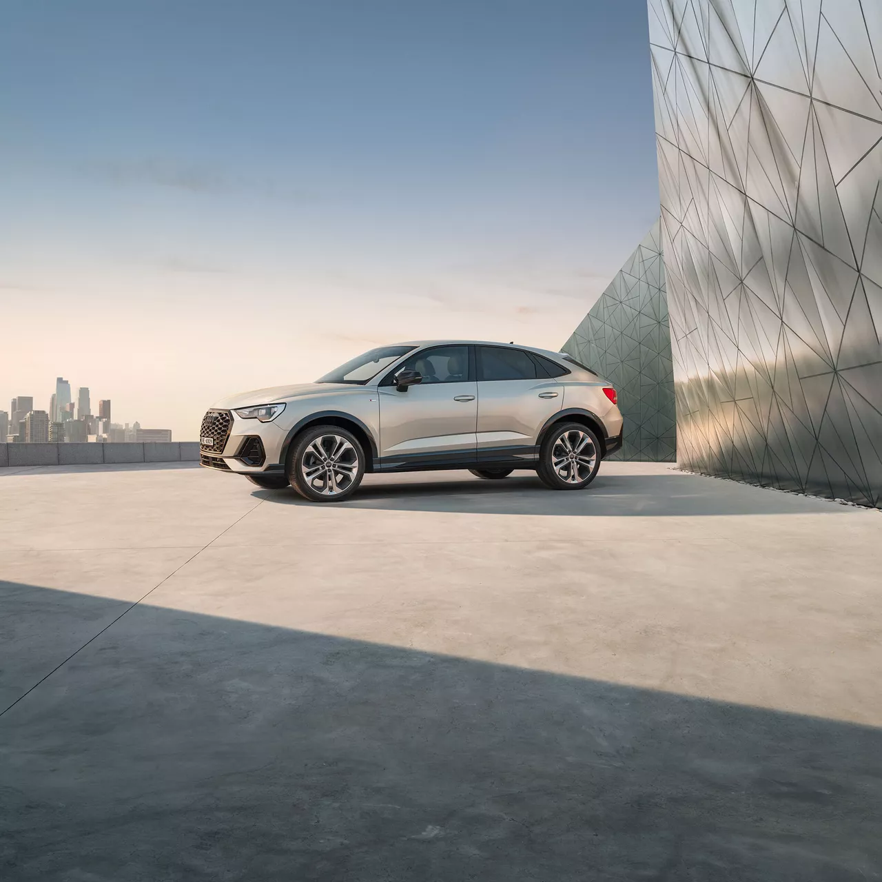 Audi Q3 Sportback argentée debout devant la façade