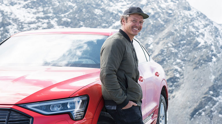 Xavier De Le Rue vor einem Audi in den Alpen