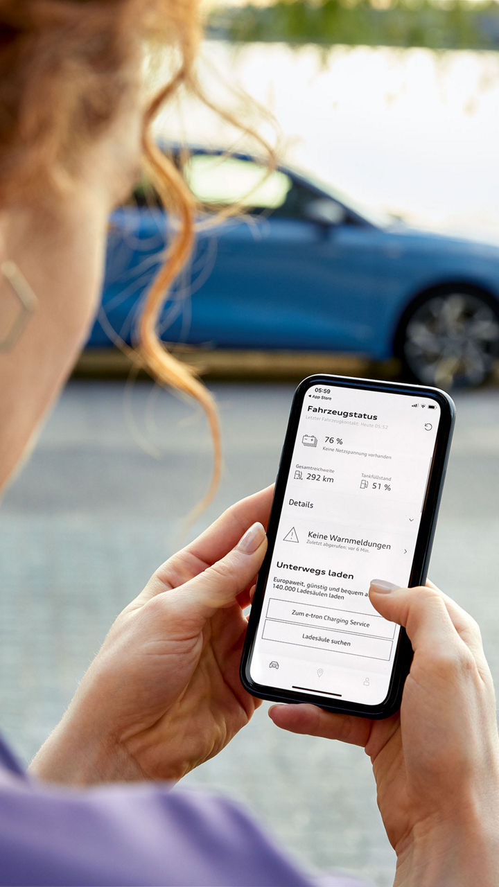 Frau checkt ihren Fahrzeugstatus auf ihrem Handy