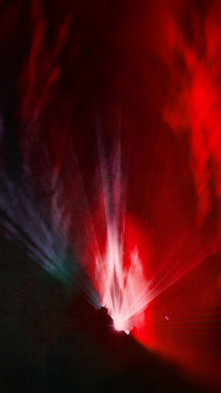 Farbiges Lichtspiel. Die Linke Bildhälfte ist durch rotes Licht erleuchtet nach rechts wechslet es in einen blaulila Farbverlauf. Während die untere linke Bildhälfte in Schwarz getaucht ist.