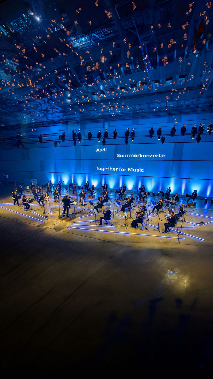 Orchester performt auf einer blau beleuchteten Bühne