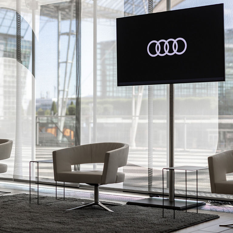 Wartebereich des Audi Conference Center, 3 helle Lederstühle mit je einem kleinen schwarzen Tisch