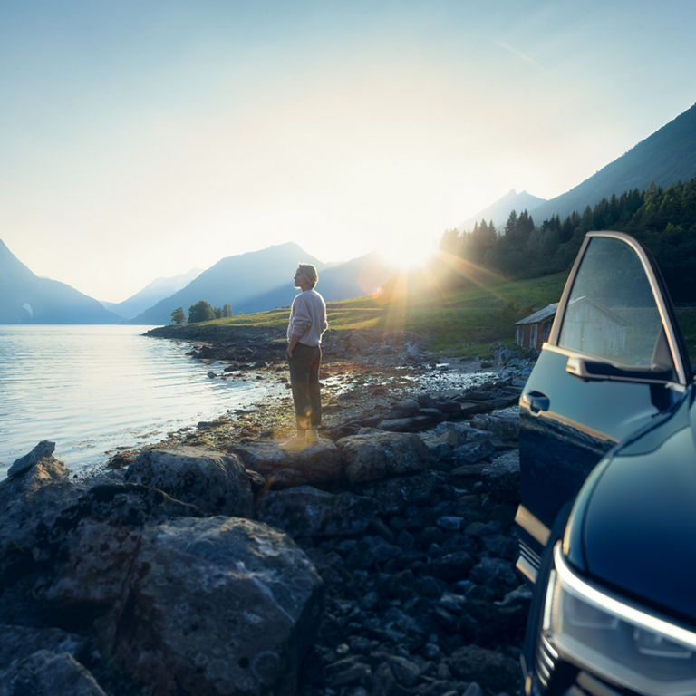 Man holding a cell phone with which he is looking at the Audi activ coach