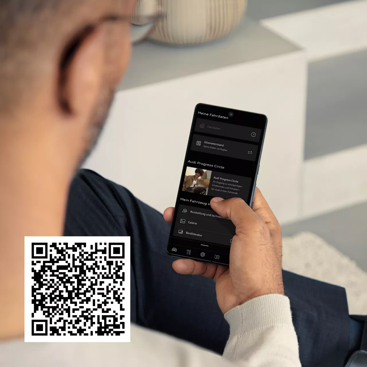 Blick auf das Handydisplay über die Schulter eines jungen Mannes. Audi Progress Circle QR-Code.