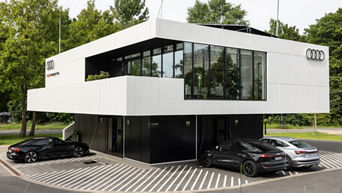 Audi charging hub Gebäude mit drei Audis vor der Tür