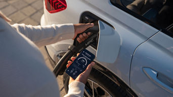 Frau steht an einem Audi und lädt es auf. 