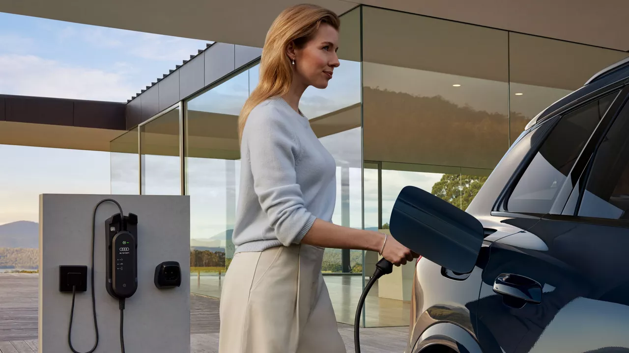Frau lädt Elektroauto auf