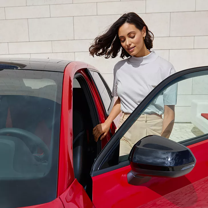 Frau steigt ins Auto